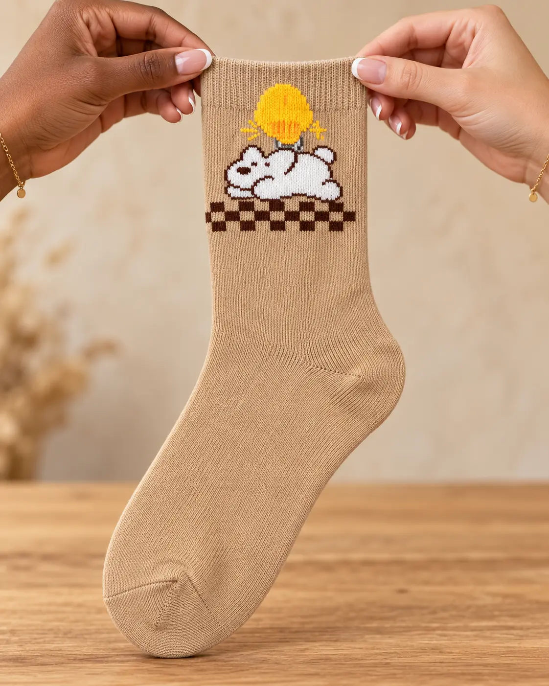 Beige socks with character in a yellow hat — held in hands
