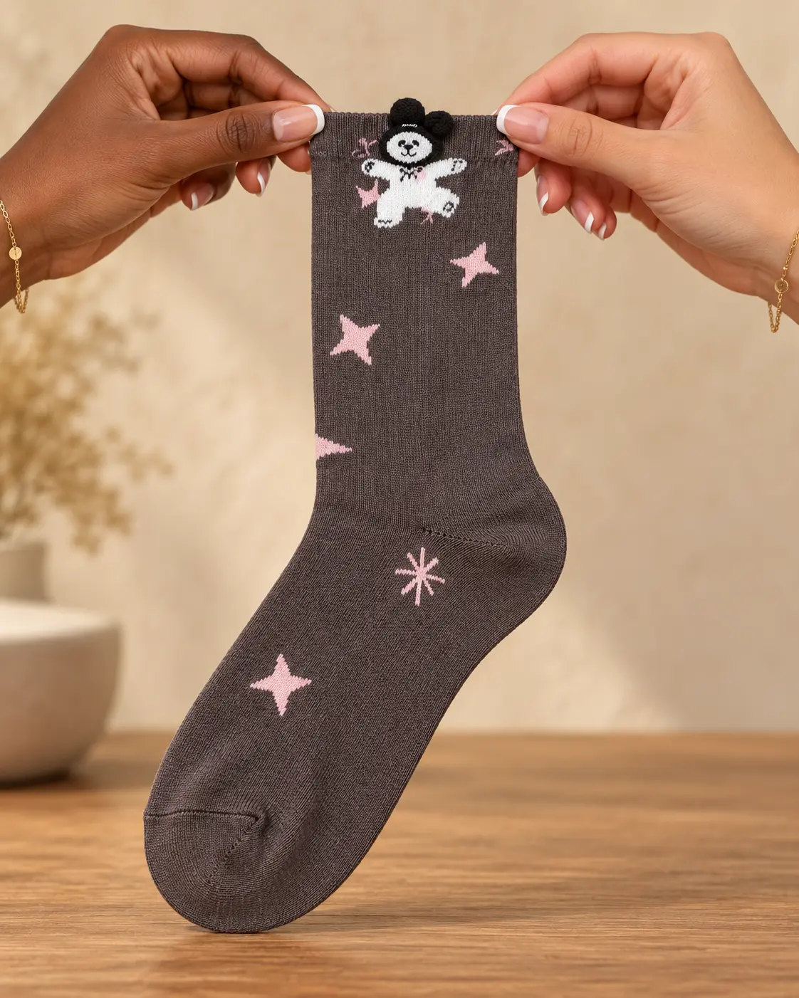 Meias cinzento-toupeira com ursinho e estrelas cor-de-rosa — segurado nas mãos