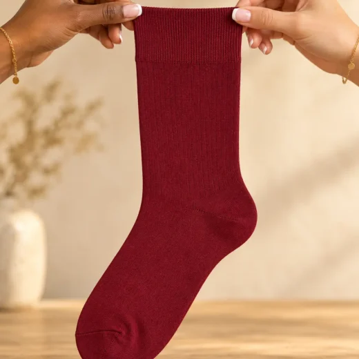 Plain burgundy socks — held in hands
